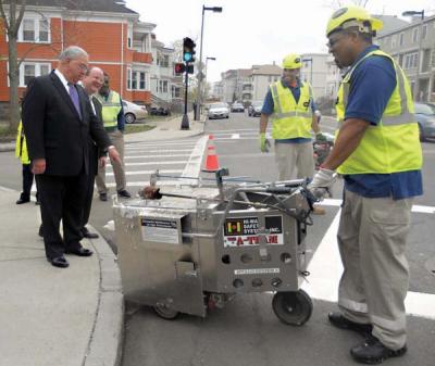 Mayor Tom Menino took time to inspect city work crews as they repaired and re-painted crosswalks and lane markers along Norfolk Street in Mattapan on Tuesday afternoon. City workers have begun an aggressive program to fix street signs and lines that have been worn by winter weather. About 600 city intersections will get repaired through the program over the new few months, according to city officials. 	Photo by Bill Forry